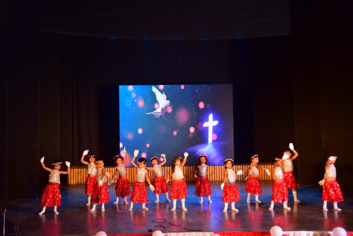 Children performing a group dance on stage