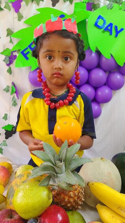 A child holding fruit at a classroom display