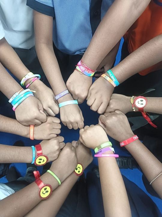 Children and adults showing friendship bands